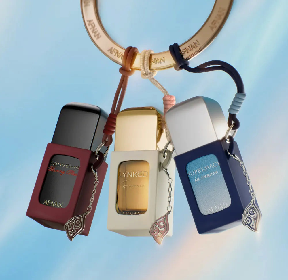 Three bottles hanging from a gold ring on cords and charms
